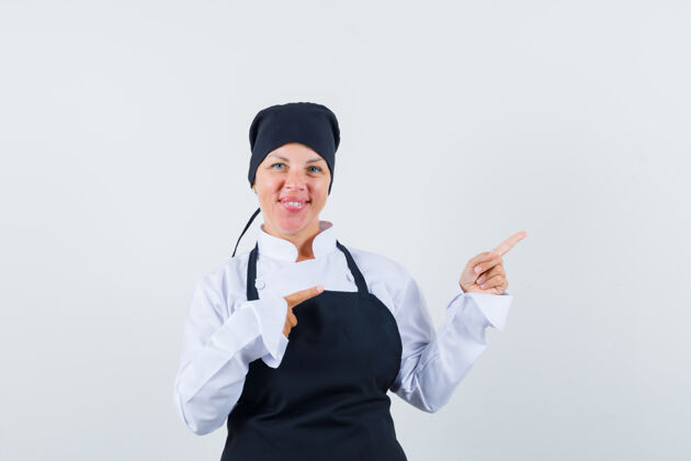 护理穿着黑色厨师制服的金发女人用食指指着右边 看起来很漂亮脸看水疗