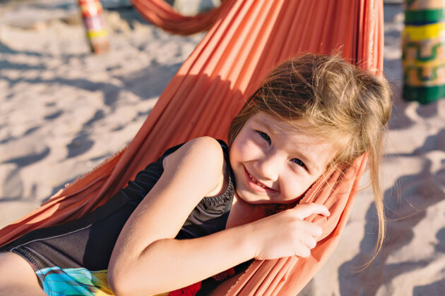 海岸海滩上穿着黑色泳衣的可爱小女孩欢乐肖像海景