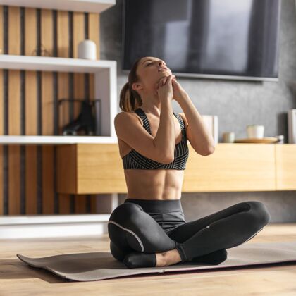 运动瑜伽垫上的女人全拍活跃运动室内