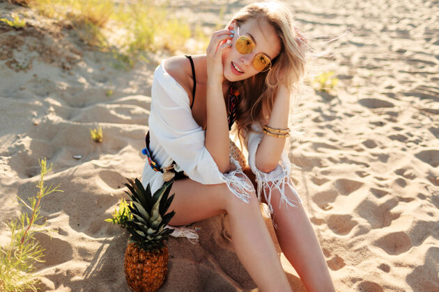 新鲜生活方式户外图片笑美丽的女人与多汁菠萝放松在阳光明媚的海滩时尚的夏季服装看女性白天