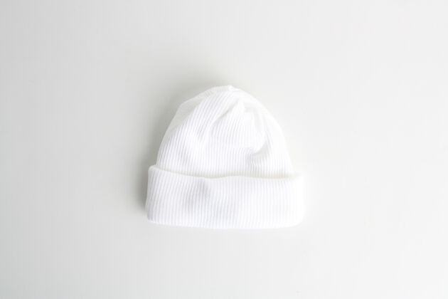 桌子特写镜头的白色羊毛婴儿帽子隔离在一个白色的背景防护单件羊毛