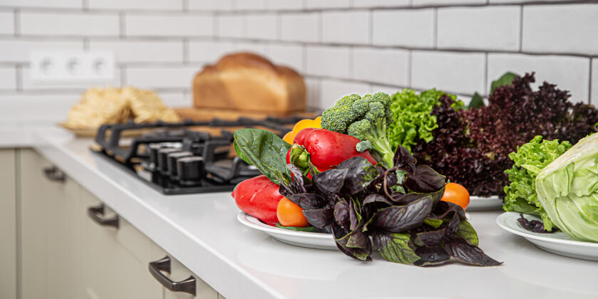 配料厨房桌子上准备沙拉的蔬菜和香草的特写镜头健康有机晚餐