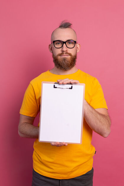 空笑容可掬的大胡子男人戴着眼镜 穿着休闲服 拿着一张白纸指着剪贴板工人信息策略