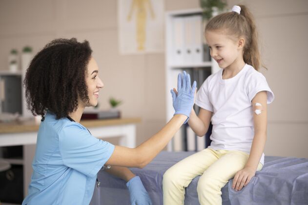 诊所年轻的医生确保一个小女孩接种疫苗后是好的女孩注射保健