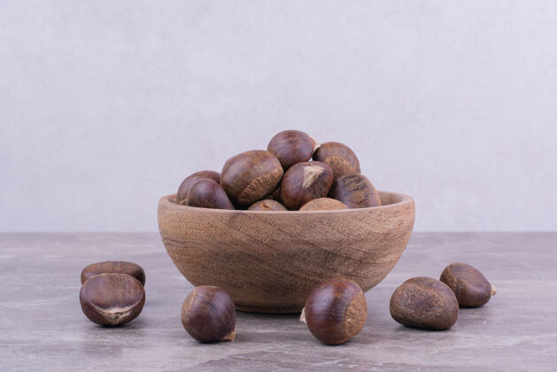 素食棕色的栗子放在一个木杯上的石头上健物美味