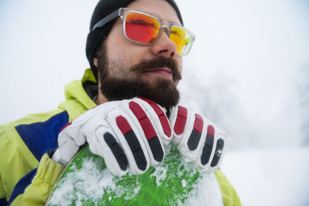 太阳镜冬天玩滑雪板的人户外特写看别处