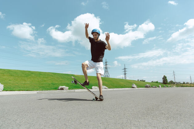 城市在阳光明媚的日子里 滑板运动员在城市的街道上玩花样锻炼年轻把戏
