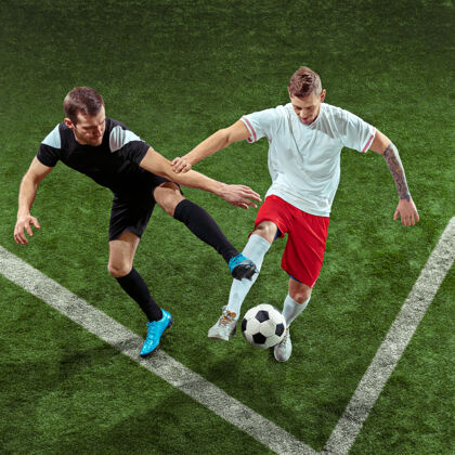 足球足球运动员在绿草墙上抢断球职业男子足球运动员在体育场运动适合在比赛中跳跃 跳跃 移动的男子成年人向前杯