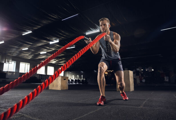 户外年轻健康的男子 运动员在健身房里用绳子锻炼身体单身男模努力练习 锻炼上身健活方式的概念 运动 健身 健美 健康力量独自运动
