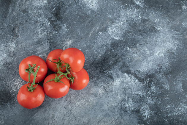 红色一些多汁的西红柿放在灰色的上面蔬菜食物有机
