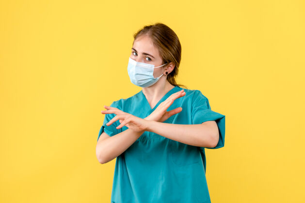 流行病正面图黄色背景上戴面罩的女医生-卫生院大流行人脸专业