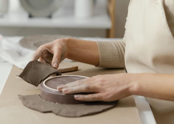 特写闭上双手做陶器房子手工生活方式