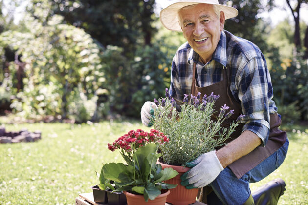 农场拿着花在地里干活的老人农作物候选人健康的生活方式