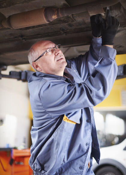 工业修理工在车间里修理汽车成年男子所有者设备