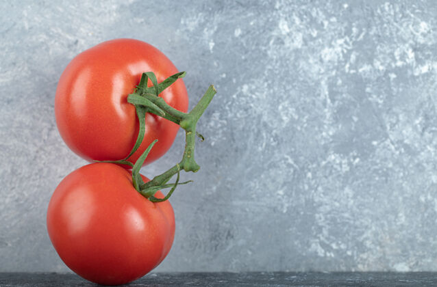 番茄两个新鲜多汁的番茄放在灰色的面包上食用红色美味