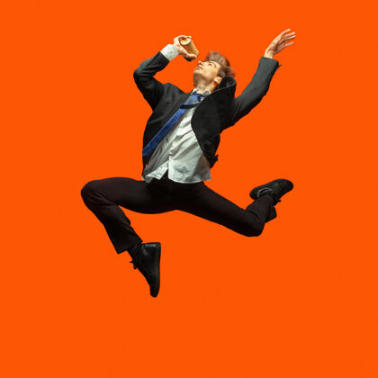 运动穿着休闲办公服的男人在明亮的橙色上跳啊跳啊跳啊精力办公室企业家