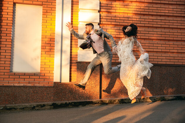 妻子高加索浪漫的年轻夫妇在城市里庆祝结婚温柔的新娘和新郎在现代城市的街道上家庭 关系 爱情的概念建筑男性新娘