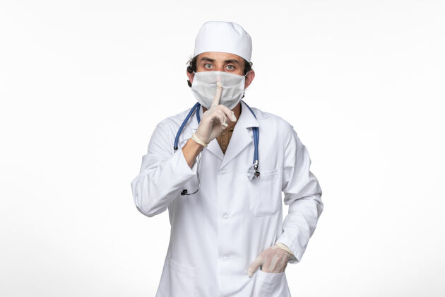 医疗正面图身穿医疗服的男医生戴着无菌口罩 以防止柯维德-白墙病毒疾病柯维德大流行疾病灯光正面男性