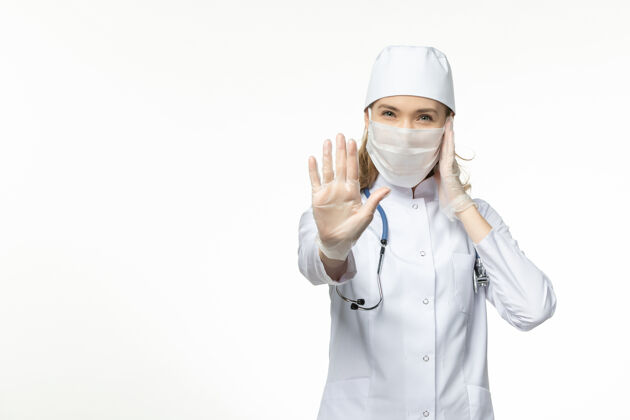 视野正面图女医生穿着医疗服戴着口罩和手套 因冠状病毒对轻白壁病大流行-冠状病毒人员无辜面罩