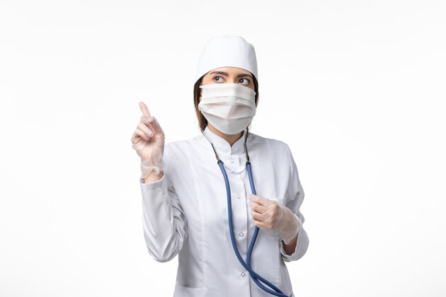 女性正面图女医生穿着白色医疗服 戴着口罩 因大流行于光壁疾病医学病毒大流行covid-外套医疗实验室外套