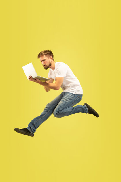 消极黄色背景上孤立的快乐跳跃人的全长肖像穿着休闲服的白人男模情绪男性广告