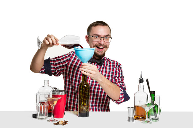 制作专家男酒吧男招待正在制作鸡尾酒在工作室隔离在白色优雅准备瓶子