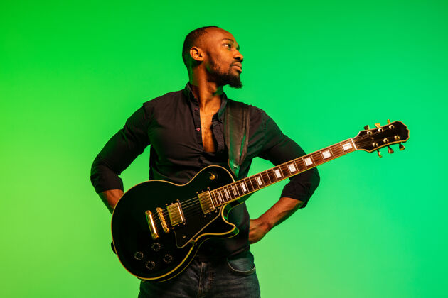 爵士乐年轻的非洲裔美国音乐家像摇滚明星一样在绿-黄渐变上弹吉他酒廊俱乐部酷