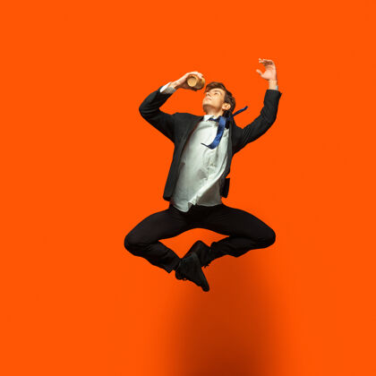 事业穿着休闲办公服的男人在明亮的橙色上跳啊跳啊跳啊企业家专业工作