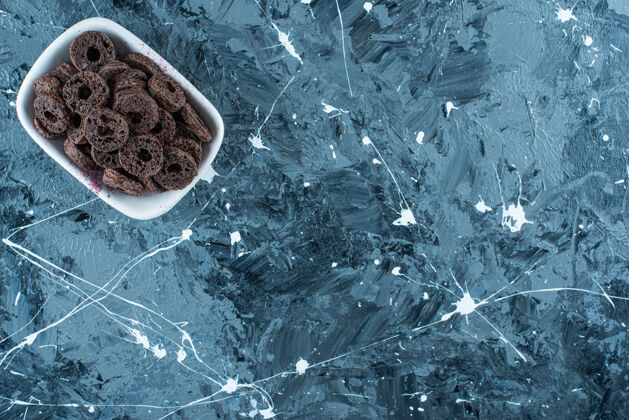 顶视图美味的巧克力涂层玉米圈在一个碗里的大理石上糖玉米片配料