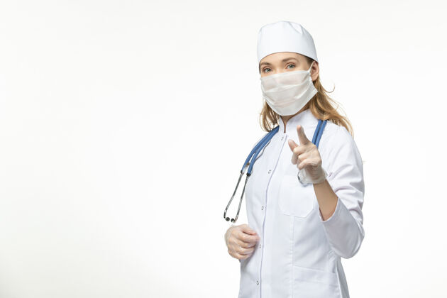 套装正面图女医生身穿白色医疗服 带无菌口罩 因白墙上冠状病毒病大流行性疾病冠状病毒-冠状病毒预防面罩视图