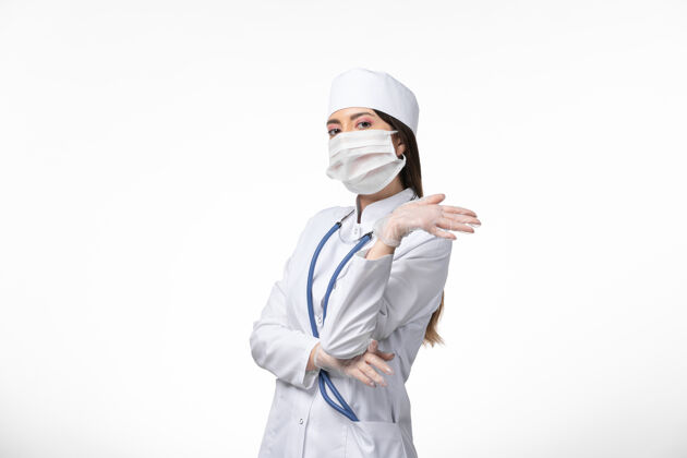 医生正面图女医生穿着白色医疗服 戴着口罩因冠状病毒对白墙健康造成疾病冠状病毒感染观点正面人