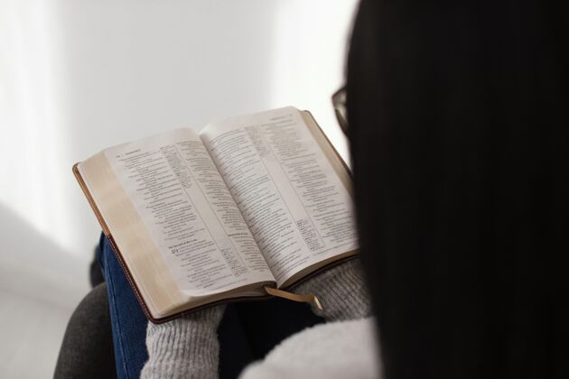 精神女人在室内读圣经希望祈祷成人