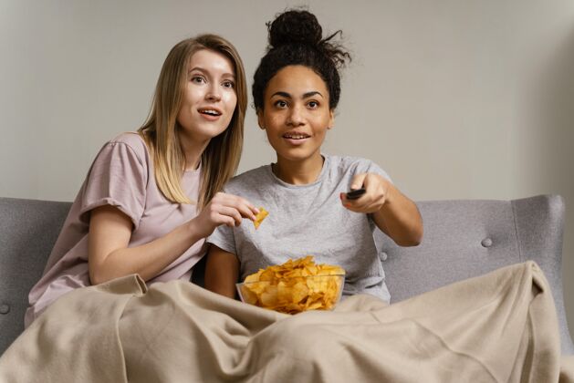 吃饭坐在沙发上看电视吃薯片的女人女人毯子室内