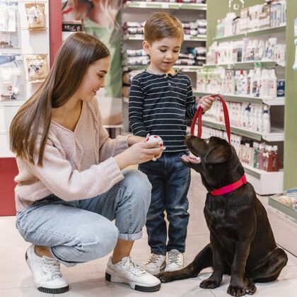 家庭孩子和妈妈在宠物店和他们的狗动物品种商品