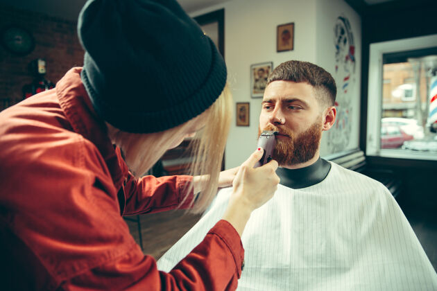 时尚客户在理发店剃须女理发师在沙龙性别平等复古配件男性