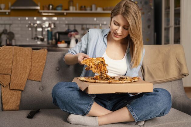 房子女人一边看电视一边吃比萨饼看电视食物吃