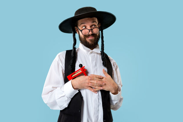 信仰一个年轻的东正教犹太男子与木制棘轮在普瑞姆节画像情感帽子以色列