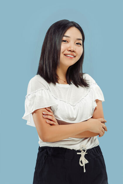 面部蓝色空间上的韩国年轻女子半身像穿着白衬衫的女模特站着微笑着手女性女人
