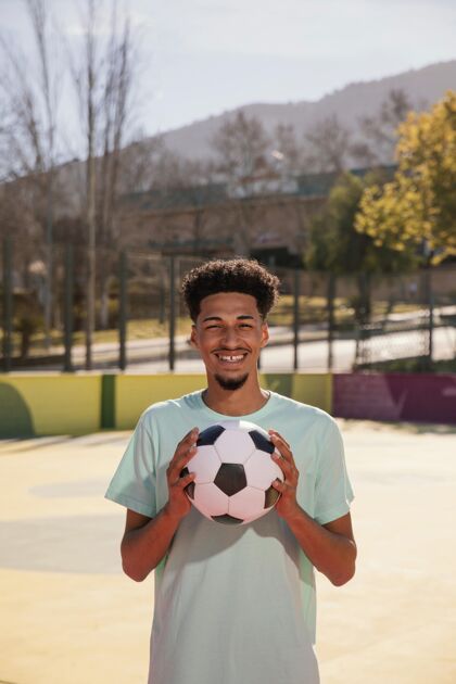 足球运动员一个拿着足球的年轻人足球足球肖像