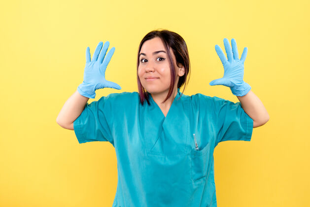 职业黄色墙上戴着医用手套的医生微笑的侧视图医学人欢呼