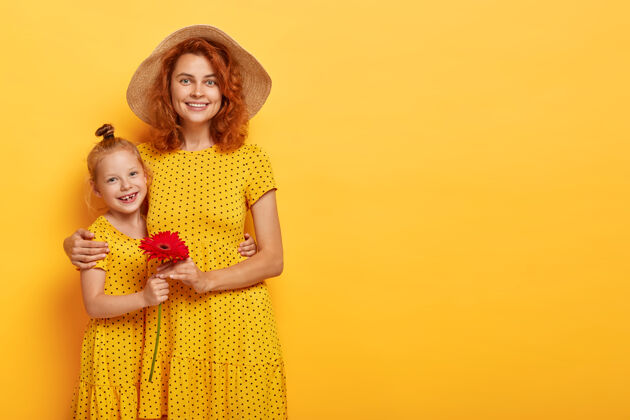 时尚美丽的红发母亲和女儿在相似的服装摆姿势的水平镜头肖像波尔卡多时尚