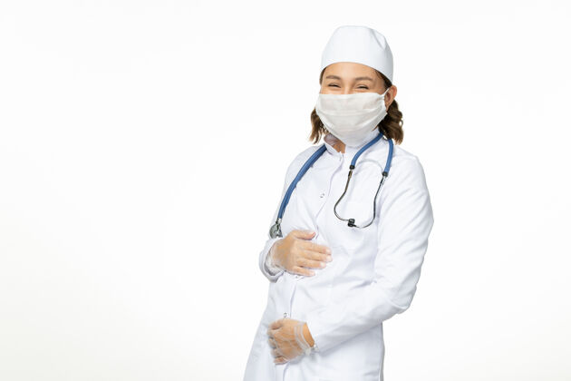 大笑正面图年轻女医生戴着消毒口罩和手套因冠状病毒在白色表面大笑医院正面大流行
