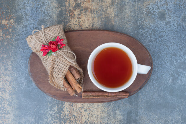 饮料粗麻布肉桂和一杯茶放在木盘上高质量的照片热的肉桂粗麻布