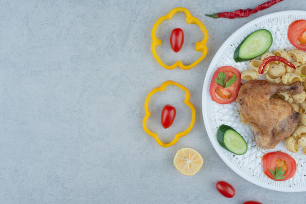 食物白色盘子上的蔬菜沙拉 大理石背景上有意大利面和鸡肉意大利面番茄蔬菜