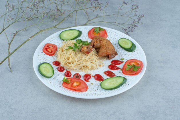 番茄酱白色盘子上的蔬菜沙拉 大理石背景上有意大利面和鸡肉蔬菜美味鸡肉