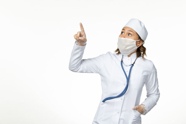 大流行正面图年轻女医生戴着无菌防护口罩 因冠状病毒直视白色表面的天空正面绝育疾病
