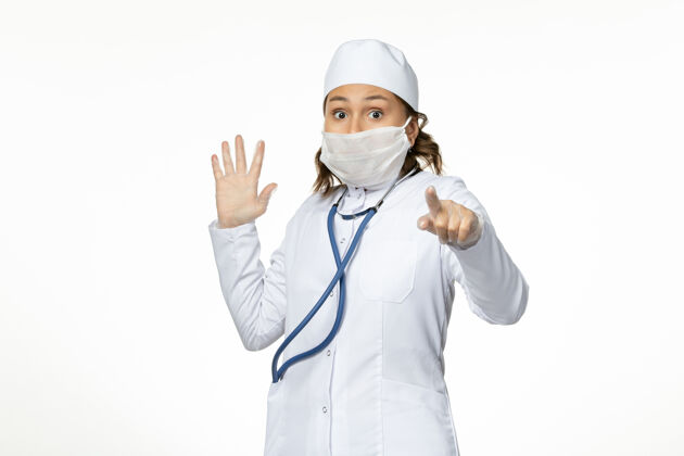 灭菌正面图年轻女医生戴着防护无菌口罩因冠状病毒吓得白脸病毒防护听诊器