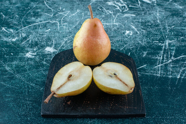 甜味两块梨在黑板上 蓝色背景高质量的照片新鲜有机天然