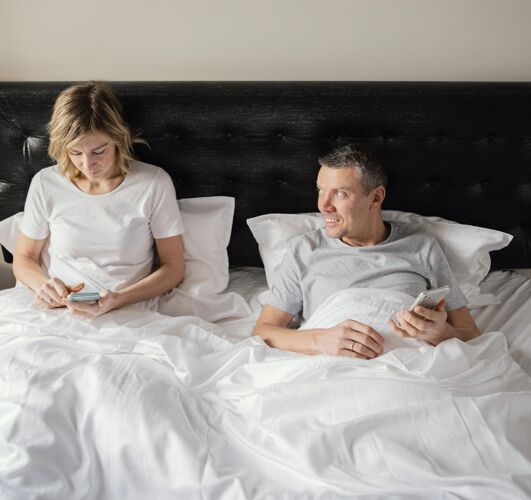 科技夫妻在床上用手机小玩意女人卧室