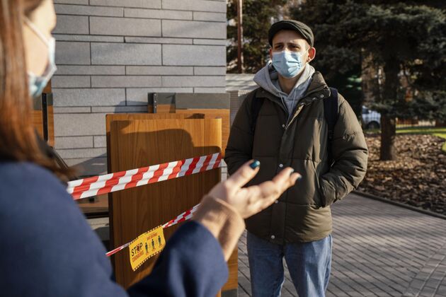 防护街上戴着面具的男人和女人社会距离冠状病毒外科面具
